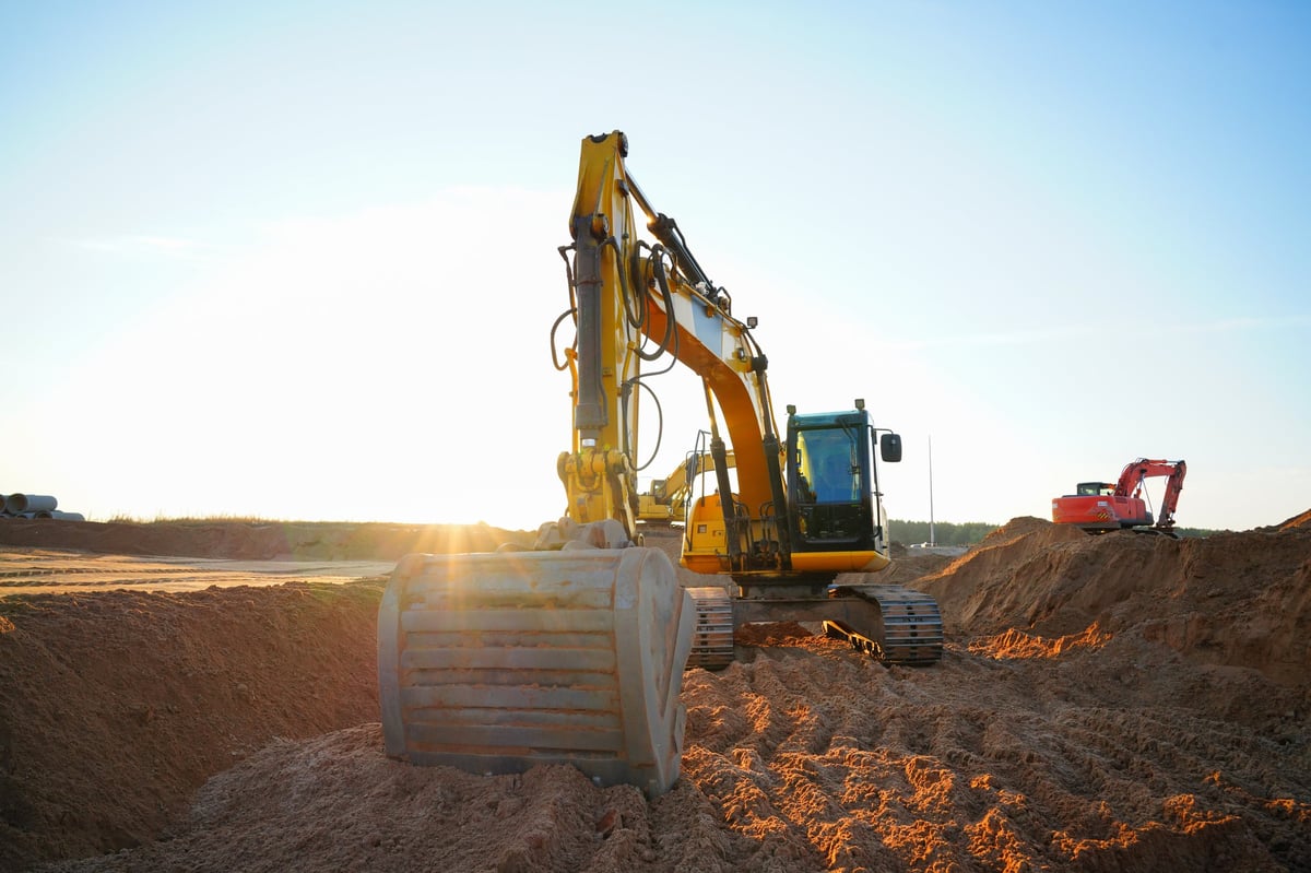 CAT excavator moving earth at golden hour on a Texas site